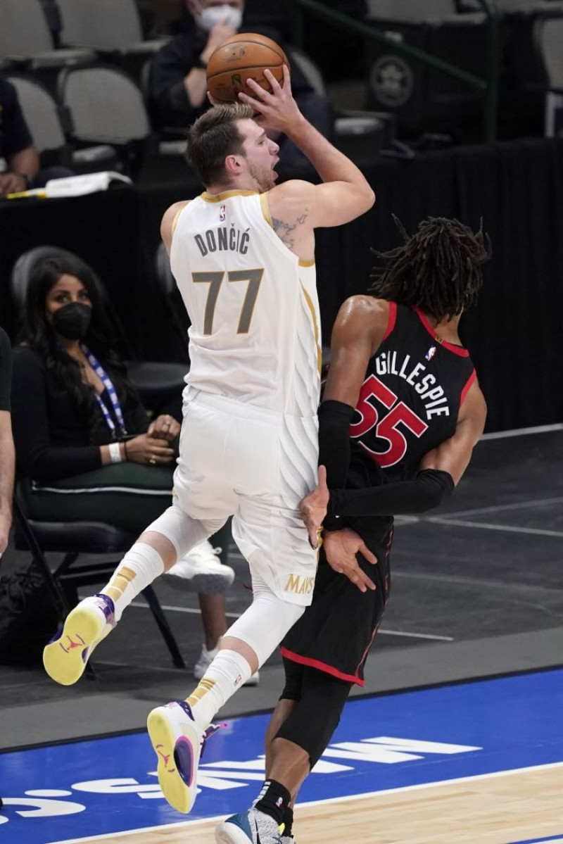Luka Doncic, base de los Mavericks de Dallas, recibe una falta de Freddie Gillespie, de los Raptors de Toronto.