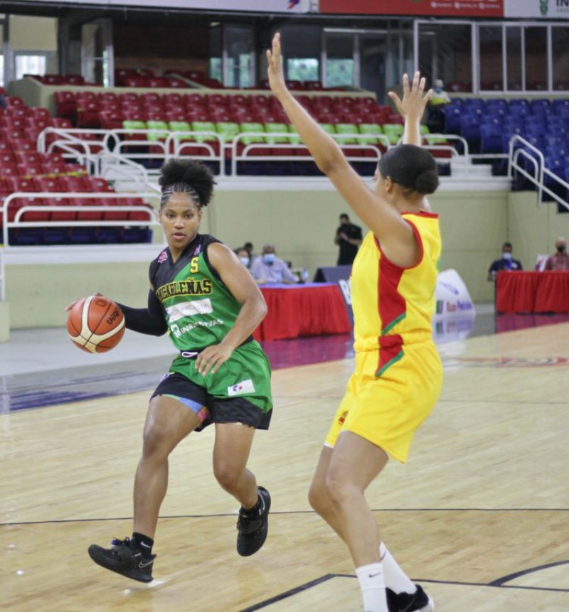 Yuleska Ramírez, de San Carlos, maneja el balón ante Julady Zapata, de las Águilas, en acción del partido del lunes en el baloncesto superior distrital.