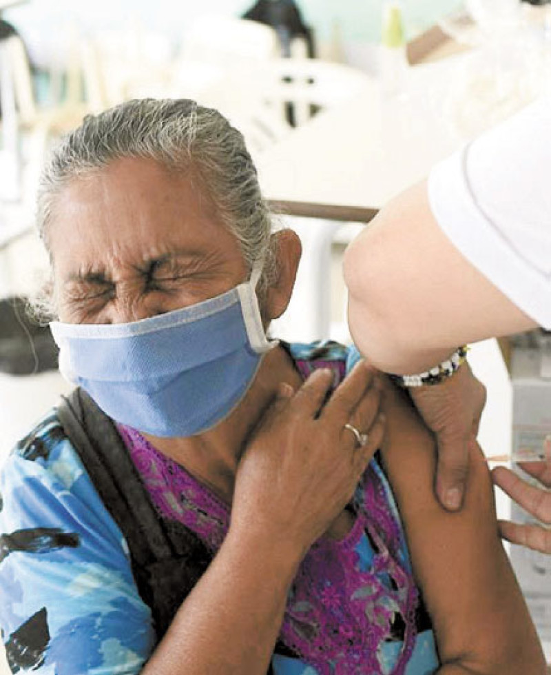 Una señora hace una mueca mientras se vacuna en el barrio Tiuna de Caracas, ayer. AP