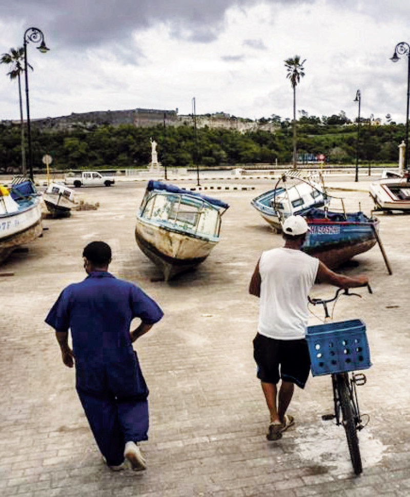 Pescadores inspeccionan sus botes después de retirarlos del agua para evitar daños con el paso de la tormenta tropical Elsa, en La Habana, Cuba. AP