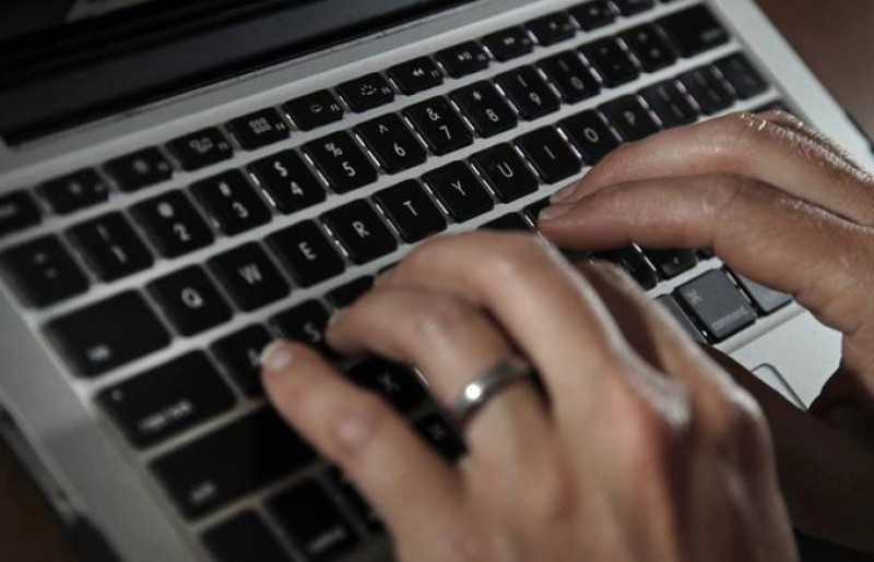 ARCHIVO - En esta fotografía de archivo del 19 de junio de 2017, una persona escribe en el teclado de una computadora portátil en North Andover, Massachusetts. (AP Foto/Elise Amendola, archivo)