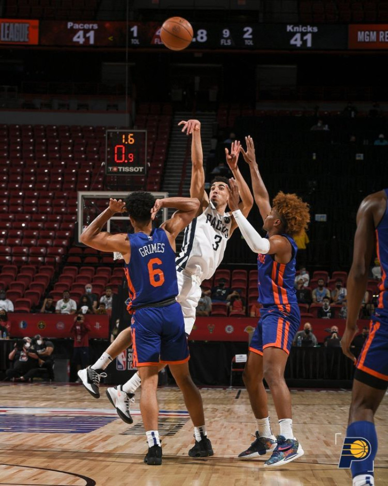 Chris Duarte, de los Pacers de Indiana, se eleva para anotar un canasto sobre dos defensores en el cierre de la primera mitad del partido frente a los Knicks.