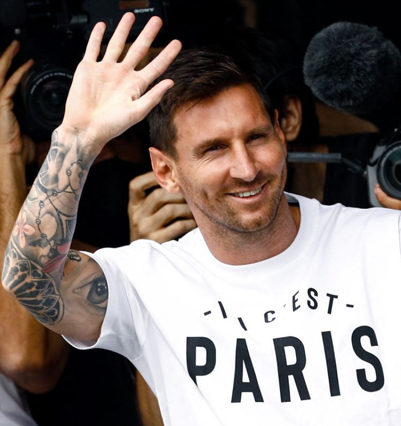 Lionel Messi saluda a los fanáticos luego de su llegada a la ciudad de París donde se espera que firme un contrato con el PSG.