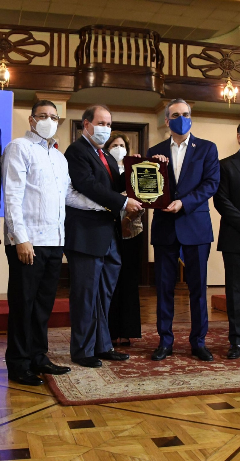 El presidente Luis Abinader entrega una placa de reconocimiento al empresario Felipe Vicini junto al ministro de deportes Francisco Camacho.