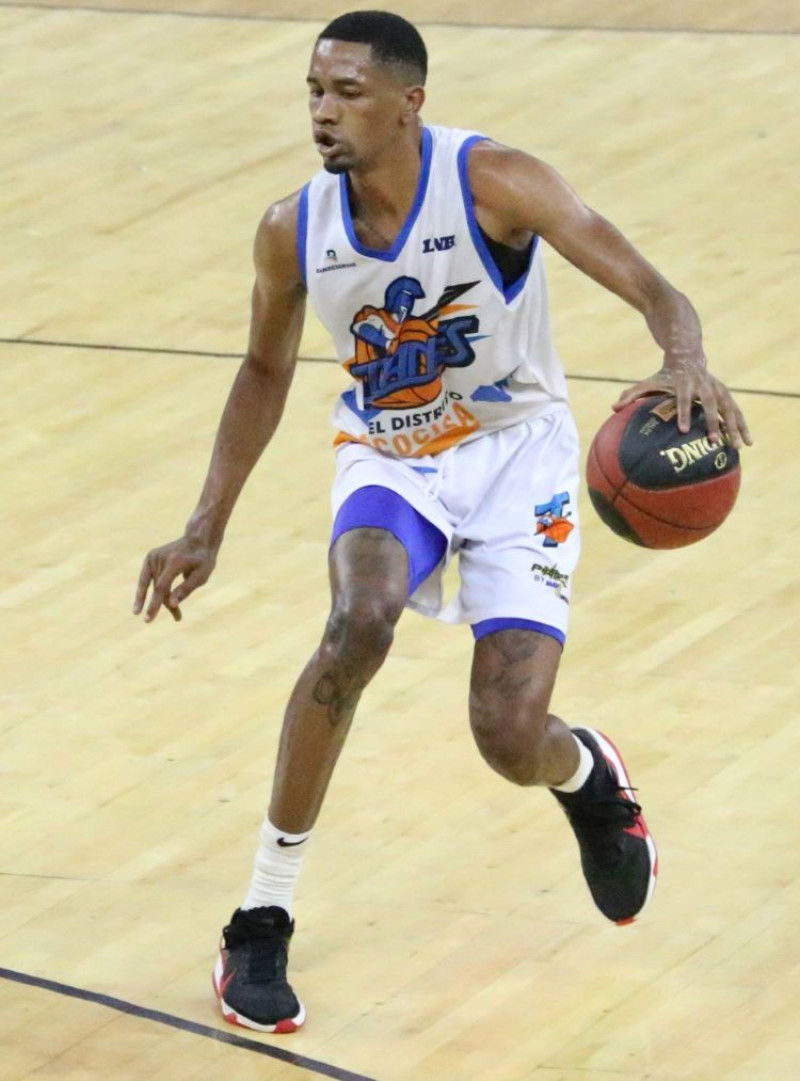 Luis Montero, de los Titanes, maneja el balón durante el partido frente a los Huracanes en el partido de la Liga Nacional de Baloncesto.