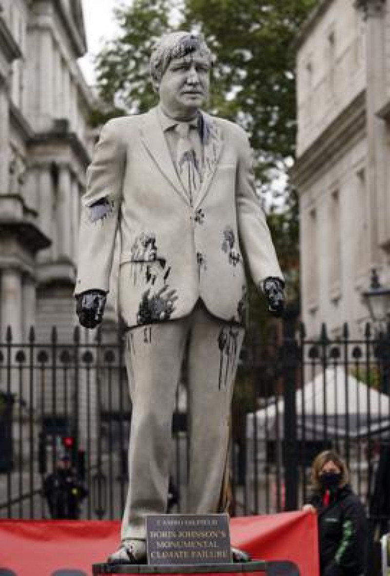 Manifestantes de Greenpeace protestan con una efigie del primer británico Boris Johnson salpicada de aceite frente a su oficina en Londres, el 11 de octubre de 2010. (Victoria Jones/PA via AP)