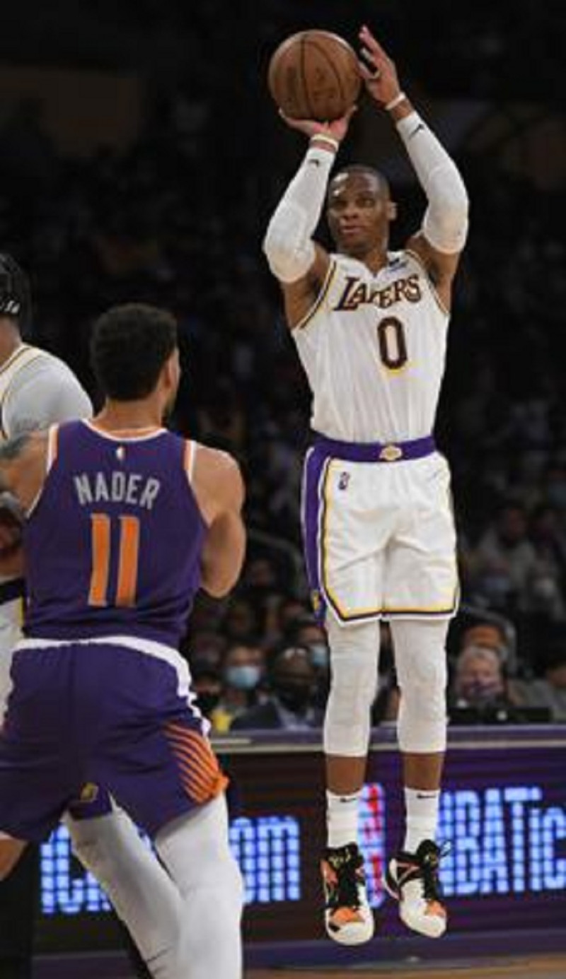 El alero de los Suns Abdel Nader observa mientras el base de los Lakers Russell Westbrook lanza el balón en el encuentro de pretemporada.