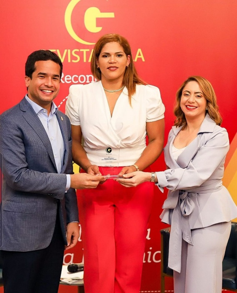 Priscilla Rivera recibe la estatuilla de manos de Omar Fernández, diputado por el DN, y Gloria reyes, directora de Supérate.