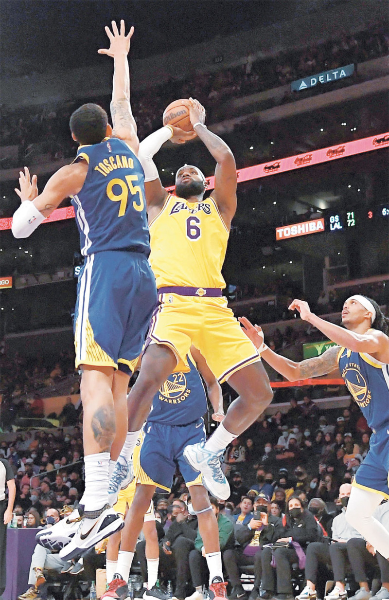 LeBron James, de los Lakers, busca un canasto sobre Juan Toscano, de los Warriors, en acción de la pretemporada.