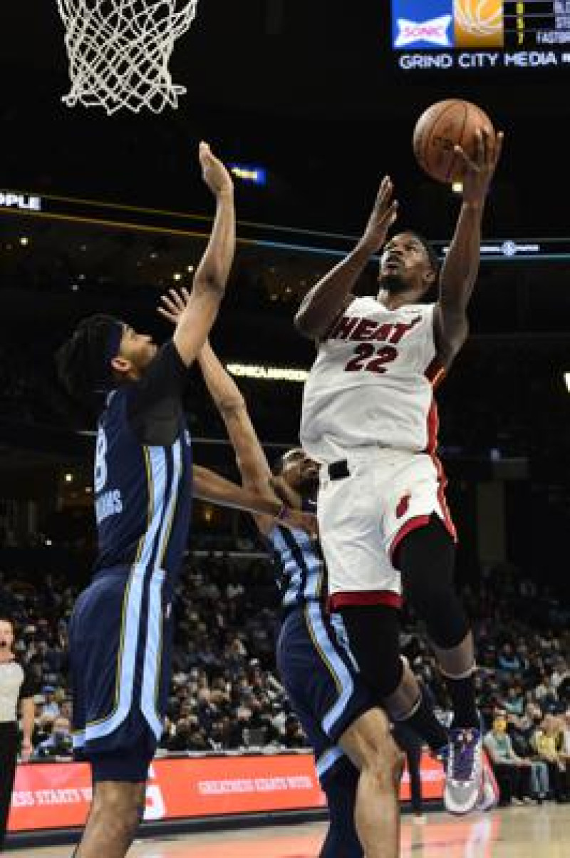 El alero del Heat de Miami Jimmy Butler lanza el balón superando al base de los Grizzlies de Memphis Ziaire Williams en el encuentro del sábado 30 de octubre del 2021.