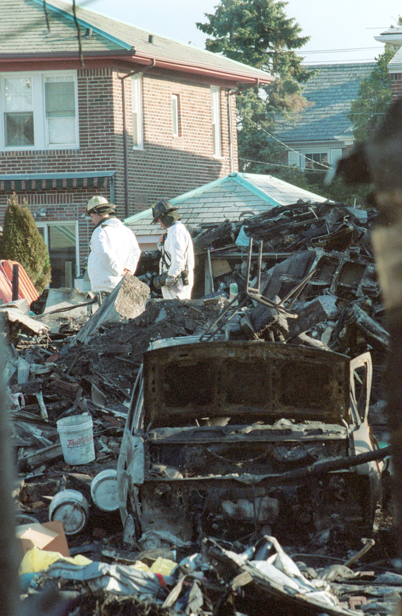 Un investigador examina los restos del vuelo 587 de American Airlines entre las casas destruidas el 13 de noviembre de 2001 en la sección Rockaway de Queens, Nueva York. La falla mecánica fue la causa más probable del accidente, que mató a las 260 personas a bordo, pero no se pudo descartar por completo el sabotaje, dijeron los investigadores. Foto de Shaul Schwarz / Getty Images