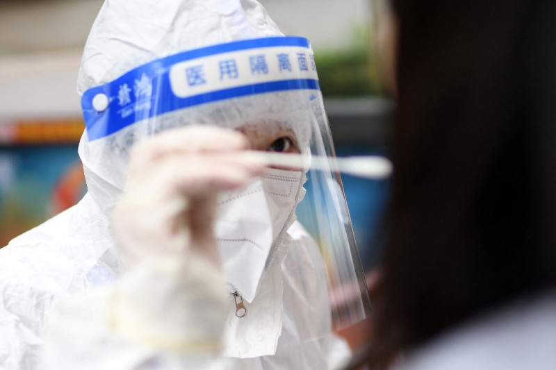 Un trabajador médico obtiene una muestra de hisopo de un residente para detectar el coronavirus Covid-19 en Wuhan, en la provincia central china de Hubei, el 22 de febrero de 2022.
STR / AFP