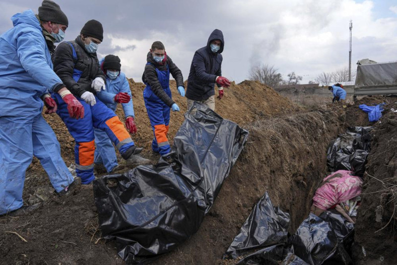 Cadáveres son colocados en una fosa común en las afueras de Mariúpol, Ucrania, el miércoles 9 de marzo de 2022. Muchas personas no pudieron enterrar a sus muertos debido al fuerte bombardeo de las fuerzas rusas. Foto:Evgeniy Maloletka/AP.