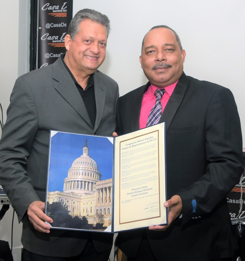 Florentino Durán recibe de Rolando Céspedes, manager de la Oficina del Bronx del congresista Adriano Espaillat la Proclama de la Cámara de Representantes de los Estados Unidos.