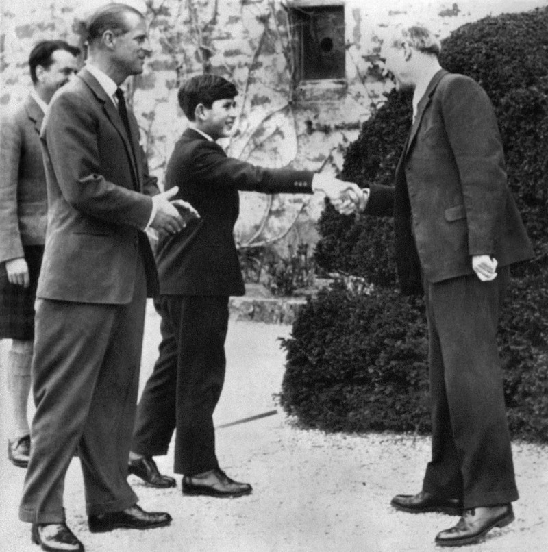 El príncipe Carlos de Gran Bretaña saluda a Robert Chew, director de la Escuela Gordonstoun, en su primer día como alumno, el 1 de mayo de 1962 a su llegada a Elgin, Escocia, mientras su padre, Felipe, duque de Edimburgo (L), observa.

Foto: AFP