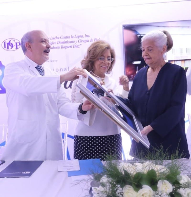 Los doctores Víctor Pou Soares, Emma Guzmán y  Luisa González de Bogaert entregan la placa de reconocimiento a la licenciada Margarita Ros.