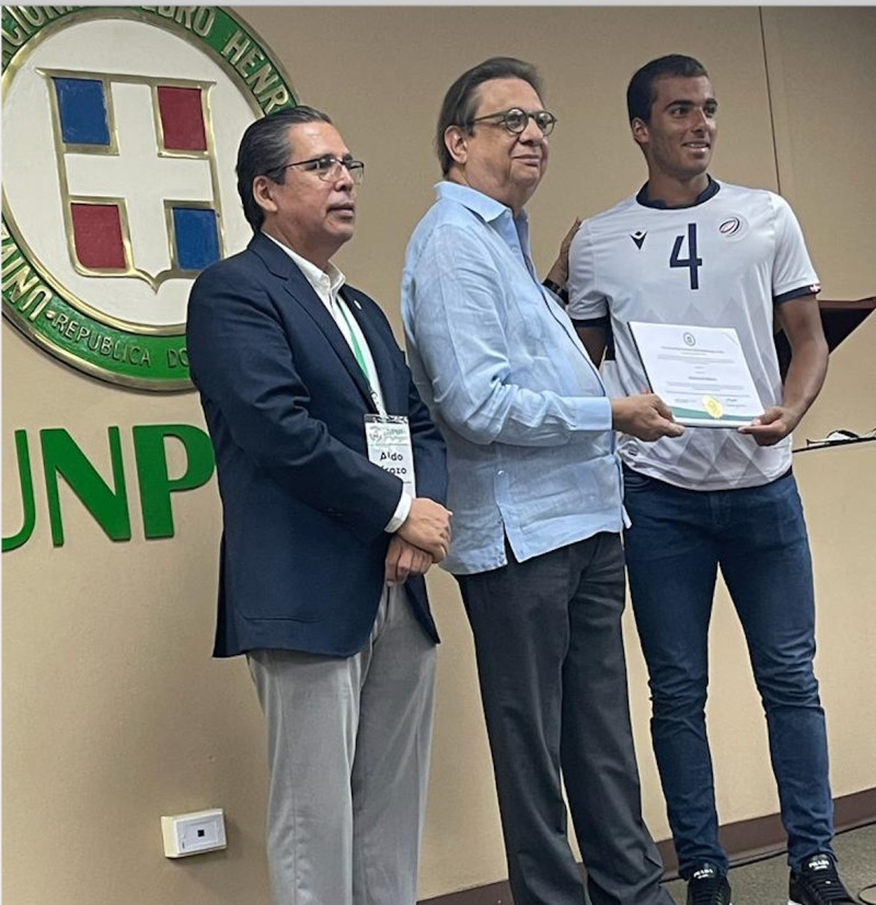 El rector de la UNPHU Miguel Fiallo Calderón entrega reconocimiento y becas a los jugadores de la selección.