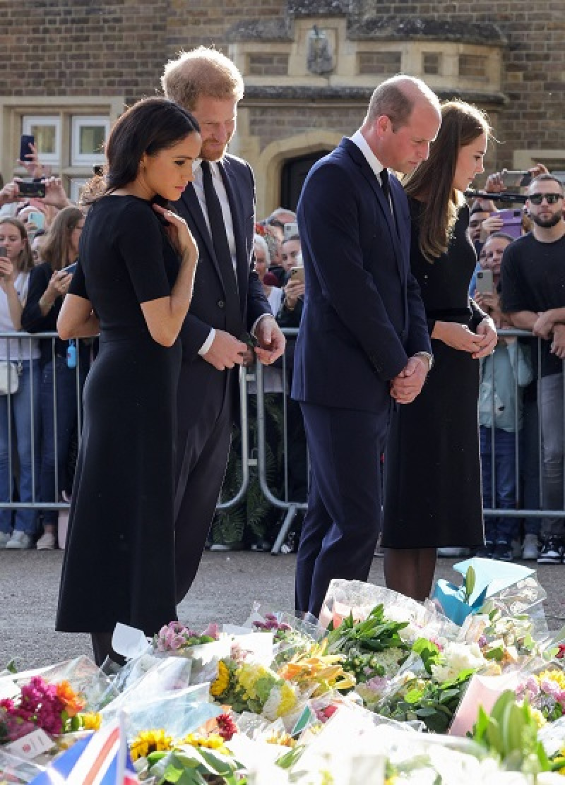 Meghan, duquesa de Sussex, el príncipe Harry de Gran Bretaña, el príncipe de Gales y la princesa de Gales de Gran Bretaña miran los tributos florales colocados por el público en el castillo de Windsor. Foto: AFP Forum.
