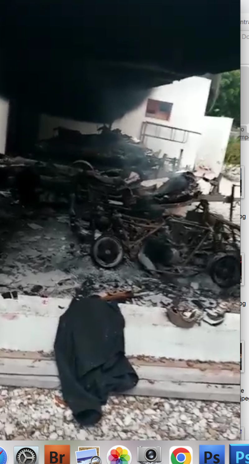 Humo, escombros y despojos de metal de vehículos incendiados en Puerto Príncipe.