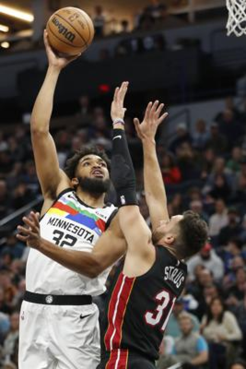 El pívot de los Timberwolves de Minnesota Karl-Anthony Towns lanza el balón sobre el base del Heat de Miami Max Strus en el encuentro del lunes en el baloncesto de la NBA.