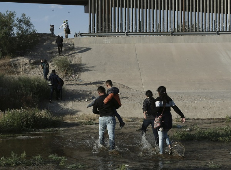 Migrantes cruzando la frontera de México con Estados Unidos. AP