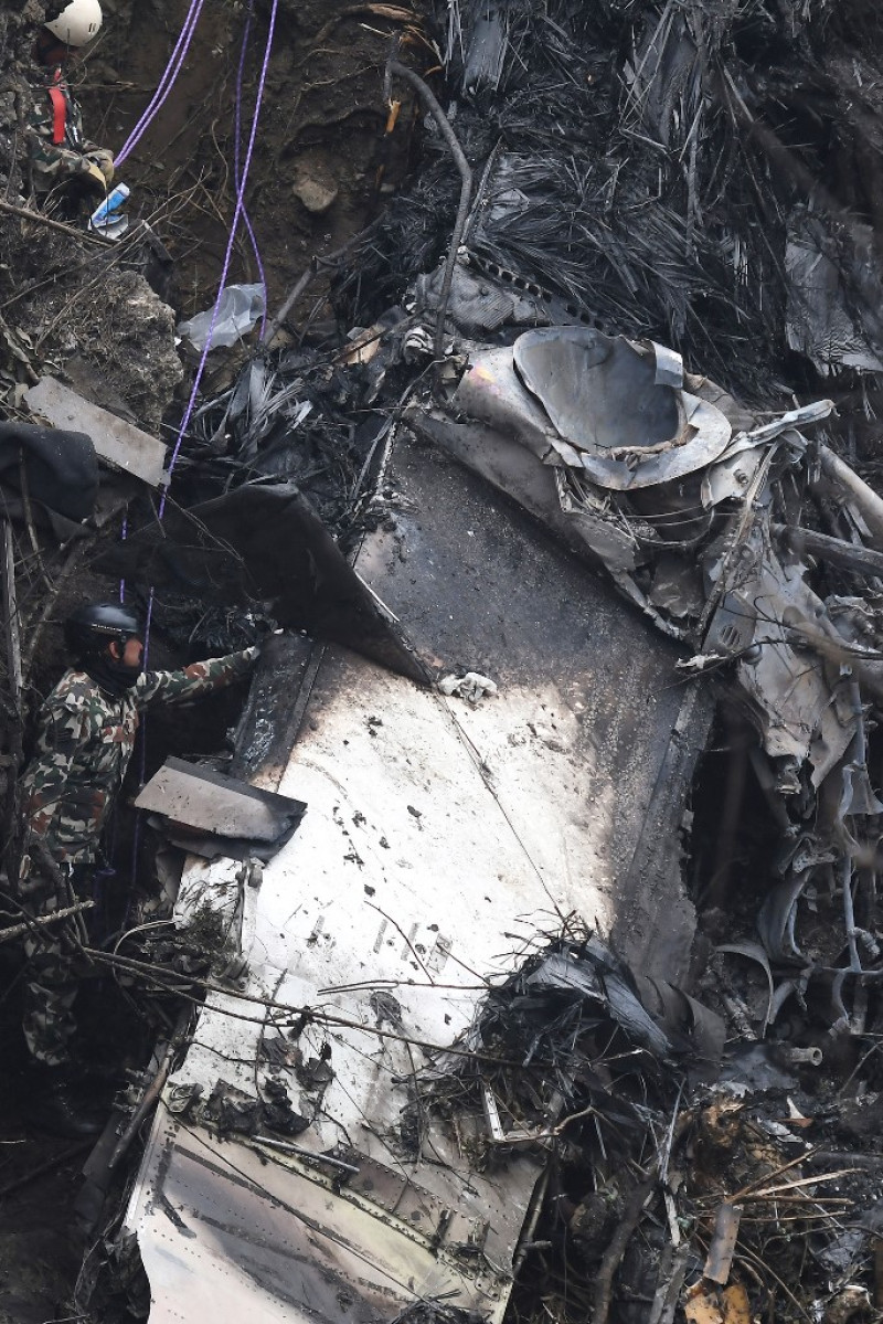 Rescatistas inspeccionan los restos en el lugar donde se estrelló un avión de Yeti Airlines en Pokhara el 16 de enero de 2023. Fuente: AFP.