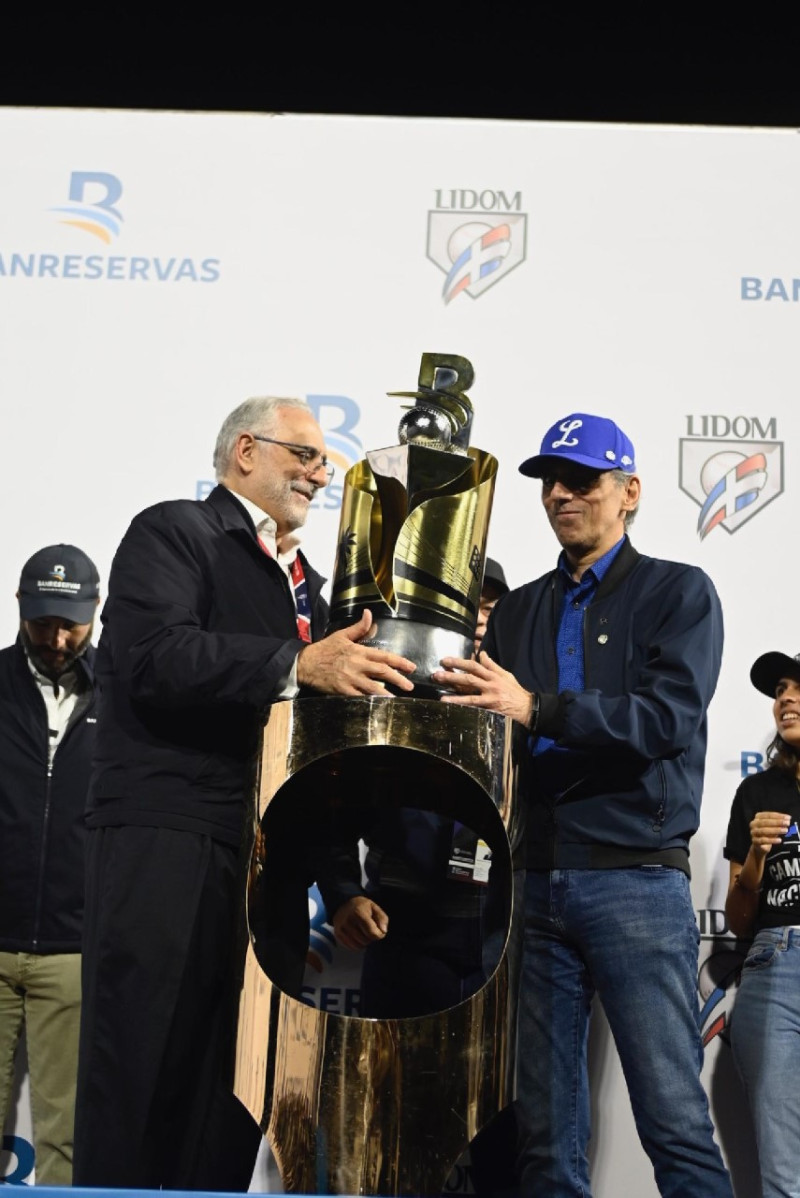 <p>El presidente del Licey Ricardo Ravelo recibe el trofeo de campeón por parte del presidente de la Liga Dominicana de Béisbol, Vitelio Mejía tras los Tigres conquistar la corona 23.</p>