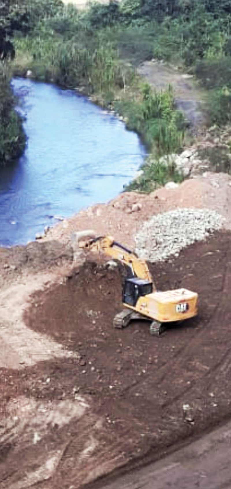 Los escombros de la reconstrucción de la carretera se depositan en el lecho del río Nizao.