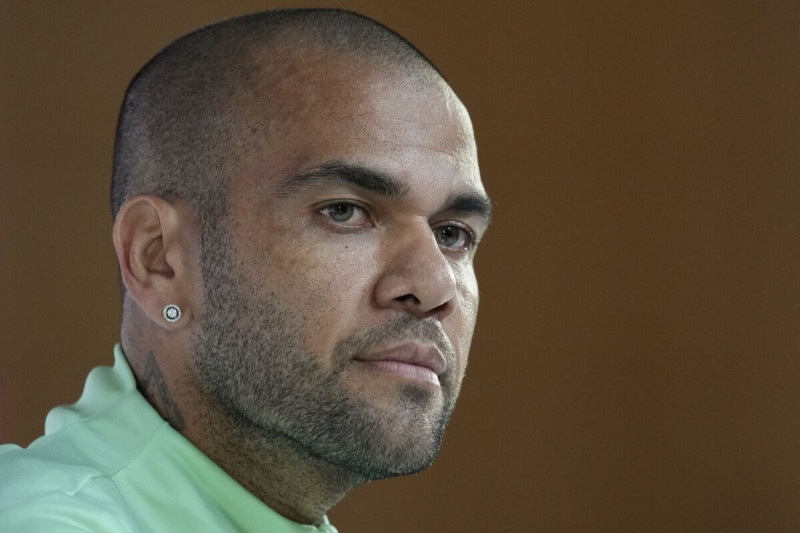 El brasileño Dani Alves escucha una pregunta durante una conferencia de prensa la víspera de un juego del Grupo G del Mundial entre Brasil y Camerún, en Doha, Qatar.