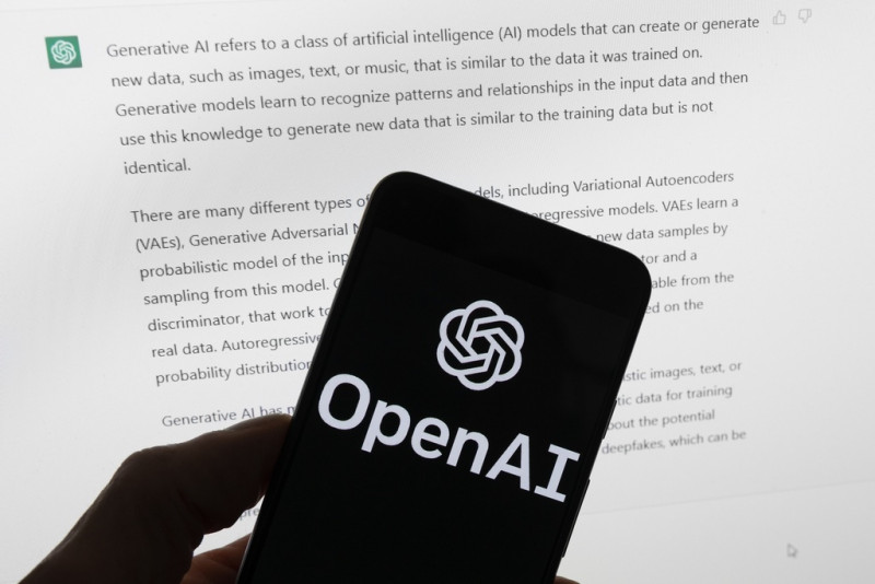 El logotipo de OpenAI se ve en un teléfono móvil frente a la pantalla de una computadora que muestra la salida de ChatGPT, el martes 21 de marzo de 2023, en Boston. (Foto AP/Michael Dwyer, archivo)
