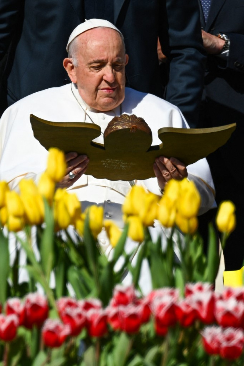 El Papa Francisco sostiene un regalo que le entregaron cuando se reunió con los invitados al final de la audiencia general semanal el 12 de abril de 2023 en la plaza de San Pedro en el Vaticano.
Foto: Vicente Pinto/ AFP