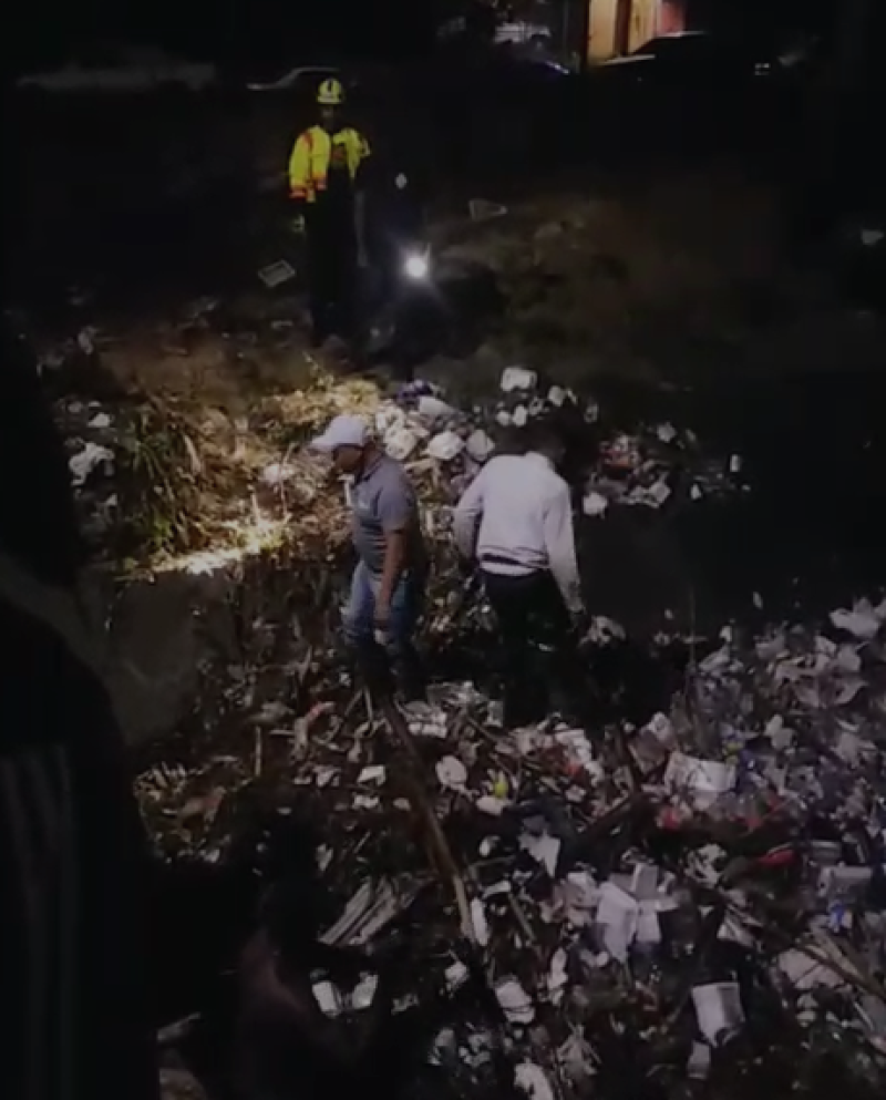 Comunitarios recogen escombros acumulados en la Cañada del barrio Las 800 la noche del domingo 23. Captura de video