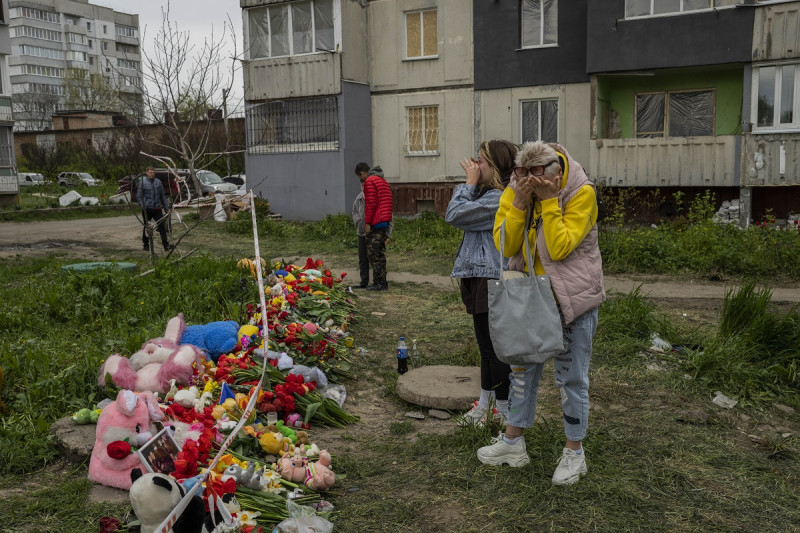 Mujeres lloran junto a un monumento a las víctimas que murieron durante el ataque ruso del viernes a un edificio residencial en Uman, en el centro de Ucrania, el domingo 30 de abril de 2023. (Foto AP/Bernat Armangue)