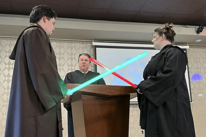Julia y Robert Jones intercambian votos durante la ceremonia de su boda en Akron, Ohio, el jueves 4 de mayo de 2023. Las parejas celebraron el 4 de mayo con una boda temática de "Star Wars".