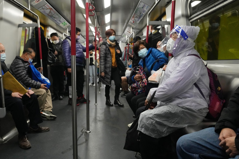 Una mujer con mascarilla y careta sentada en un tren en Hong Kong, el miércoles 23 de febrero de 2022. Archivo