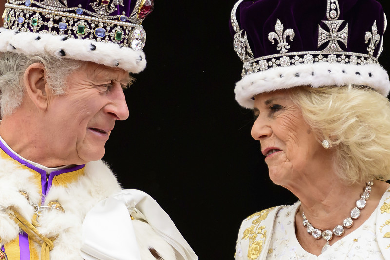 El rey Carlos III de Gran Bretaña y la reina Camila se miran desde el balcón del Palacio de Buckingham después de su coronación, en Londres, el sábado 6 de mayo de 2023.