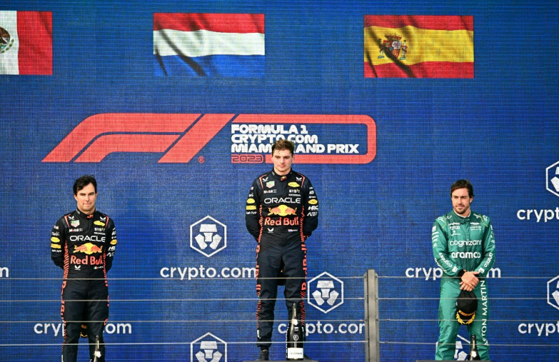 El piloto mexicano de Red Bull Racing, Sergio Pérez, que ocupó el segundo lugar, el piloto holandés de Red Bull Racing, Max Verstappen, que ocupó el primer lugar, y el piloto español de Aston Martin, Fernando Alonso, que ocupó el tercer lugar, celebran en el podio después del Gran Premio de Fórmula Uno de Miami 2023 en el Autódromo Internacional de Miami en Miami Gardens, Florida, el 7 de mayo de 2023.