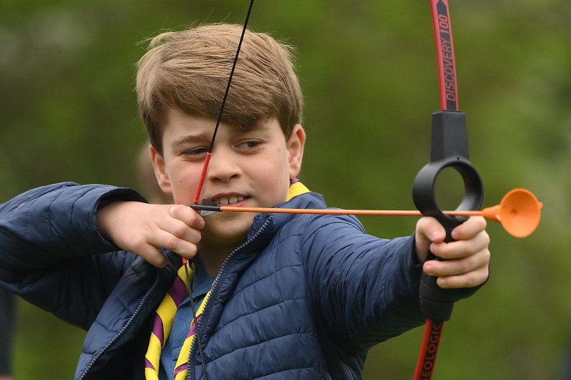 El príncipe George de Gales de Gran Bretaña prueba el tiro con arco mientras participa en Big Help Out.