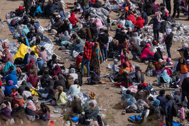 Migrantes esperan ser procesados ​​por las autoridades estadounidenses en el lado estadounidense de la frontera entre Estados Unidos y México, el 11 de mayo de 2023.