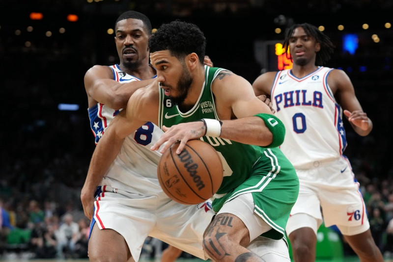 El alero de los Boston Celtics, Jayson Tatum, centro, conduce hacia la canasta pasando a los guardias de los Philadelphia 76ers.