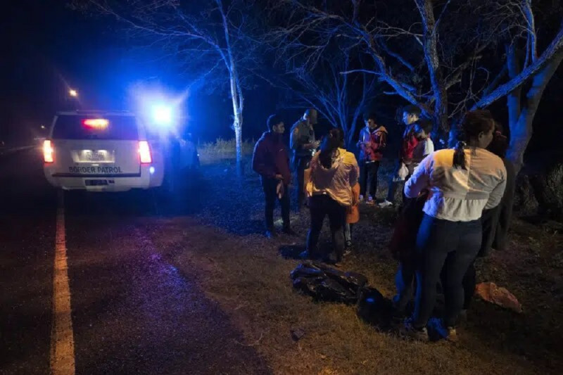 Un agente de inmigración detiene a un grupo de migrantes centroamericanos cuando caminaban en una carretera tras haber cruzado la frontera entre Texas y México, el viernes 12 de mayo de 2023, en Fronton, Texas.