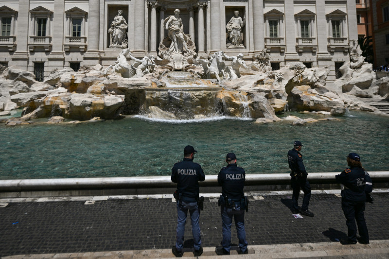La policía hace guardia el 21 de mayo de 2023 en la fuente Fontana di Trevi en el centro de Roma después de que los activistas ambientales de Última Generación (Ultima Generazione) vierten líquido negro