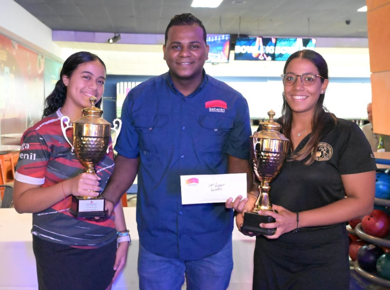 Junior Luna,  ejecutivo del Sebelén Bowling Center, premia a  Carmina Hermón y Leticia Santos.