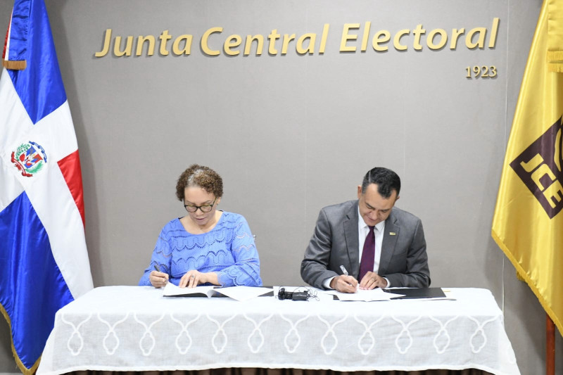 Miriam Germán y Germán Liranzo firman el acuerdo que permitirá votar a los reclusos.