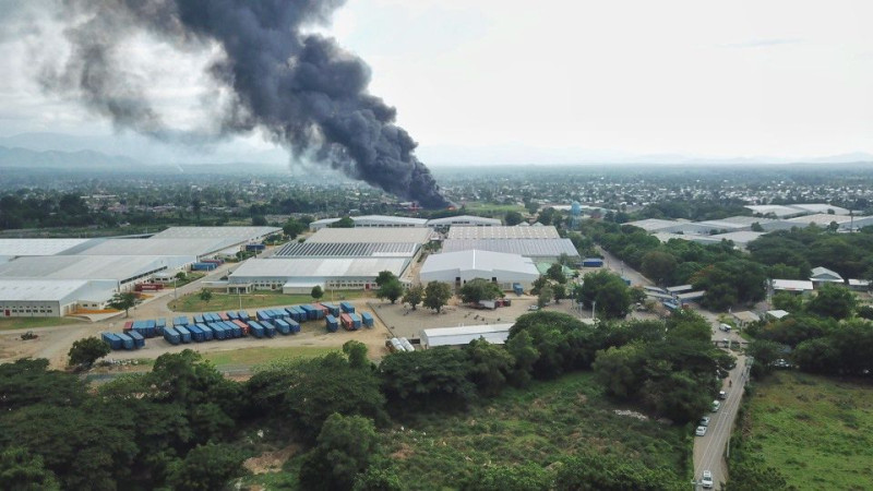 Una espesa nube de humo se levanta por encima de una de las instalaciones del parque industrial Codevi, como resultado de la confrontación entre la seguridad privada de esa compañía  y haitianos que trabajan en esa corporación.