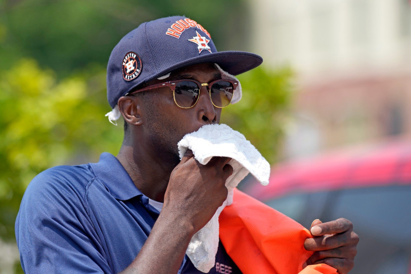Donnay Wright, quien trabaja en un estacionamiento, se limpia el sudor del rostro mientras trabaja afuera del Minute Maid Park antes de un partido de béisbol entre los Rojos de Cincinnati y los Astros de Houston el sábado 17 de junio de 2023, en Houston.