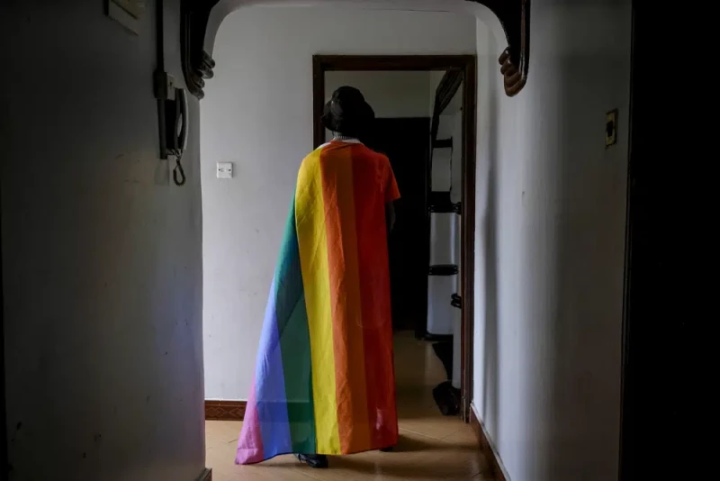 En esta imagen de archivo, un hombre ugandés homosexual posa para una fotografía cubierto con una bandera del orgullo gay, en Uganda, el 25 de marzo de 2023.