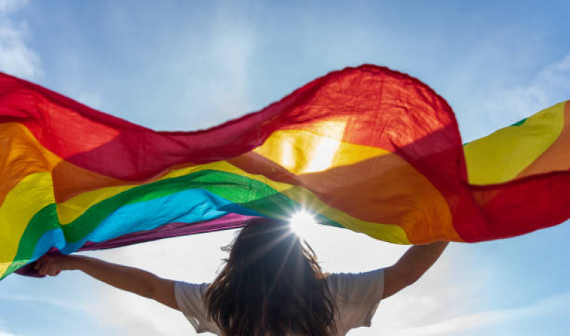 Mujer joven ondeando la bandera LGBTQ.
