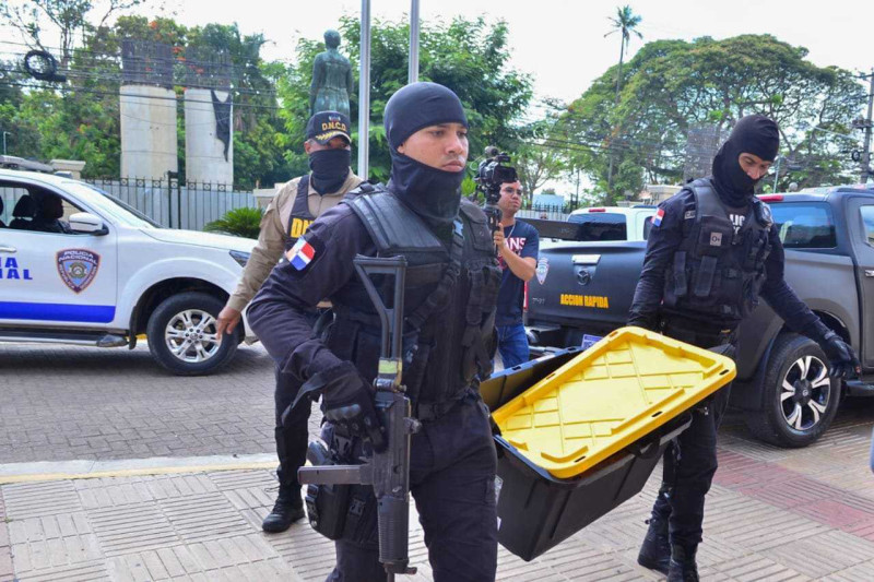 Personal fuertemente armado de la Dirección Nacional de Control de Drogas(DNCD) cargan evidencias recogidas durante un operativo.