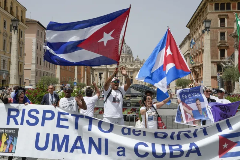 Miembros de la comunidad cubana en Italia ondean banderas del país y cantan consignas contra el presidente de Cuba, Miguel Díaz-Canel, durante su audiencia con el papa Francisco, en el Vaticano, ayer.